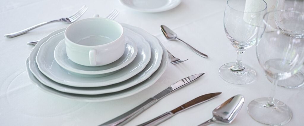 Klassisches weißes Porzellan-Gedeck mit Suppentasse, Besteck und Weinglas – elegantes Mietgeschirr von Partyladen von Voss